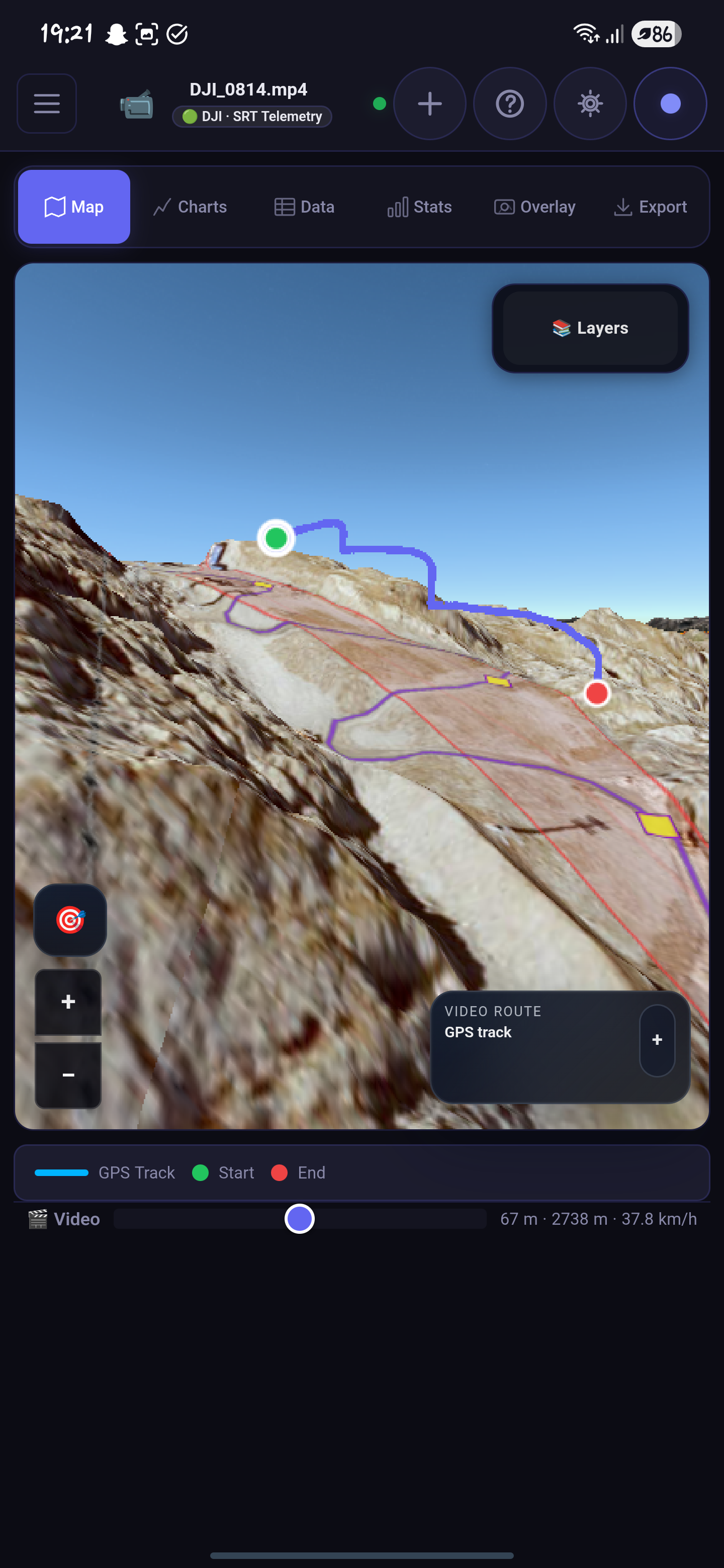 Phone screenshot of a 3D terrain map with a blue route, start and end markers, and floating layer controls.
