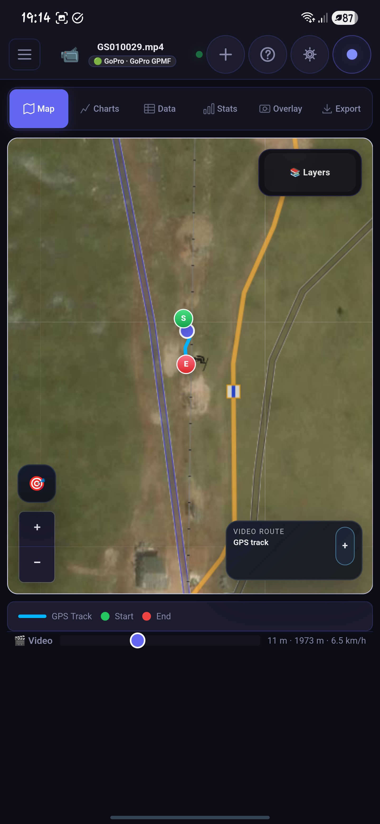 Phone screenshot of a top-down map with a GPS track, start and end markers, a scrubber, and floating layer controls.